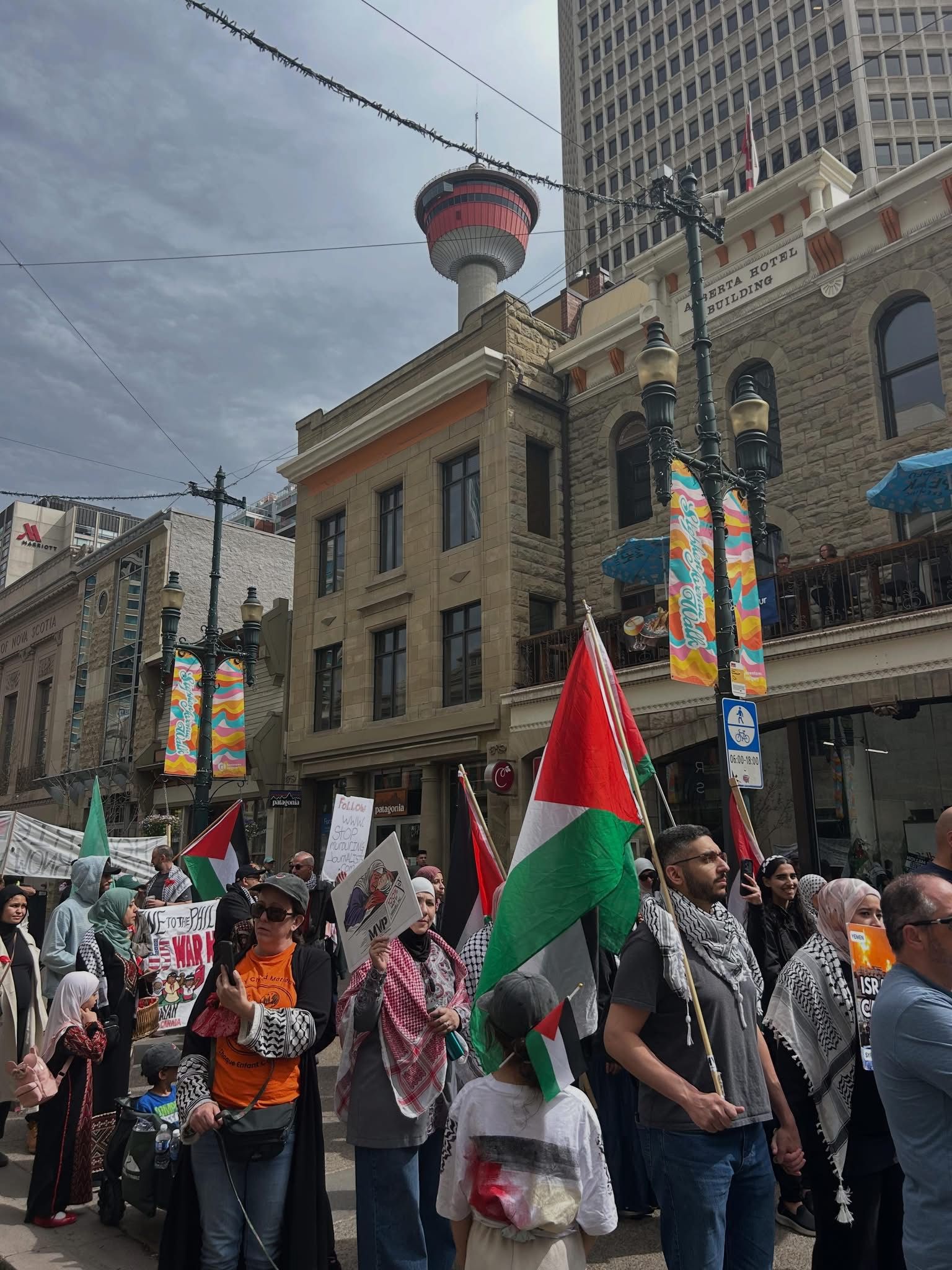 Families marching with Palestinian flags through downtown Calgary