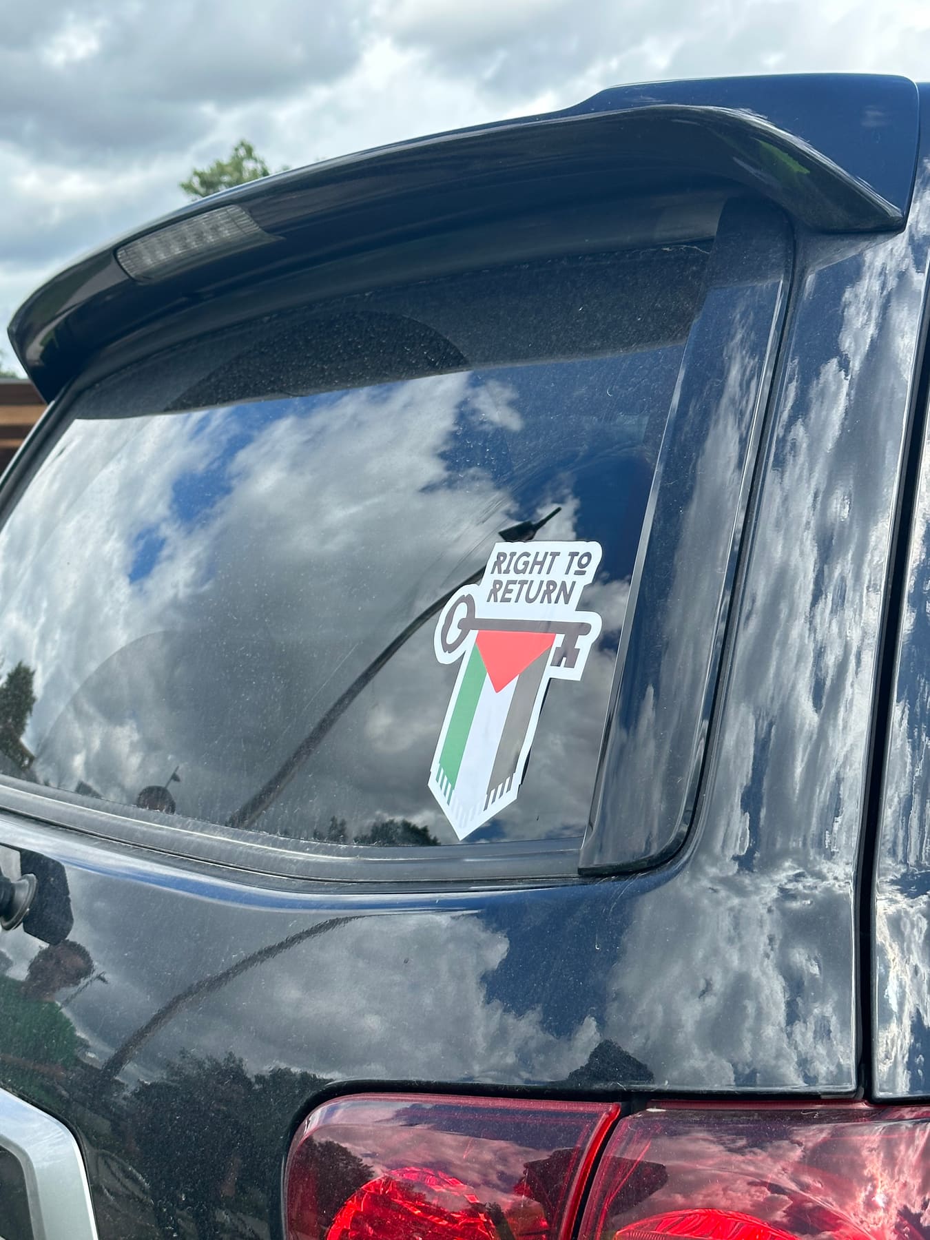 A “Right to Return” key-and-flag sticker on the rear window of a car